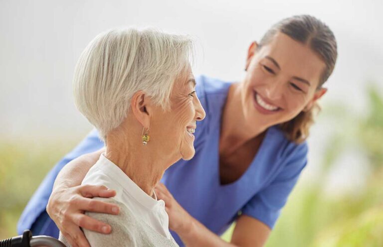 Residents talking and laughing together at a table in a cozy, shared common room.