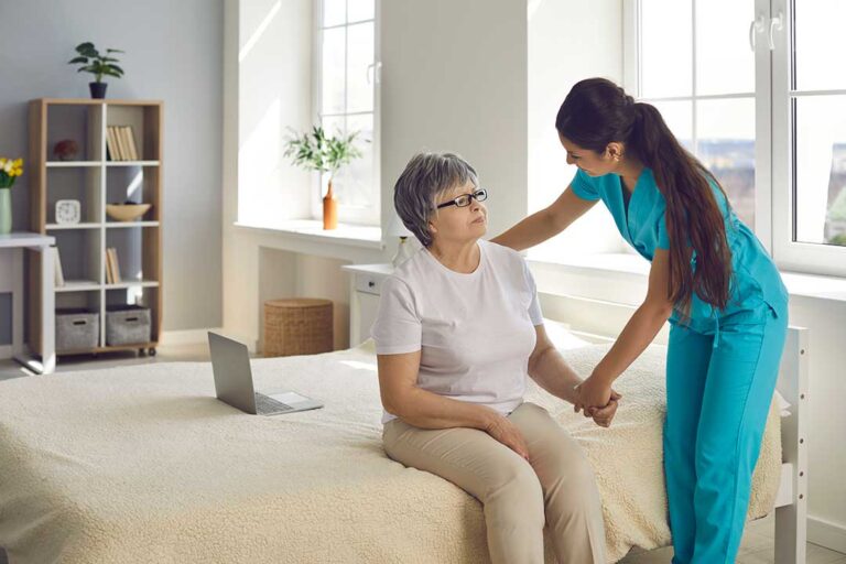 Caregiver reviews a personalized care plan with an older resident at a dining table.