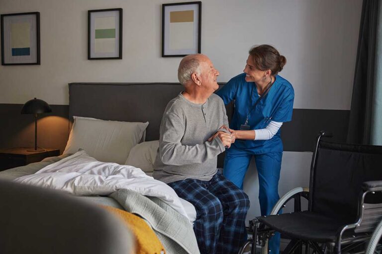 Older adults join a seated music and movement activity in a bright assisted living common room.